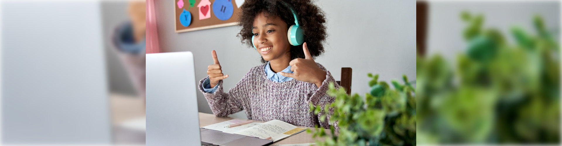 girl looking at laptop with headphones smiling
