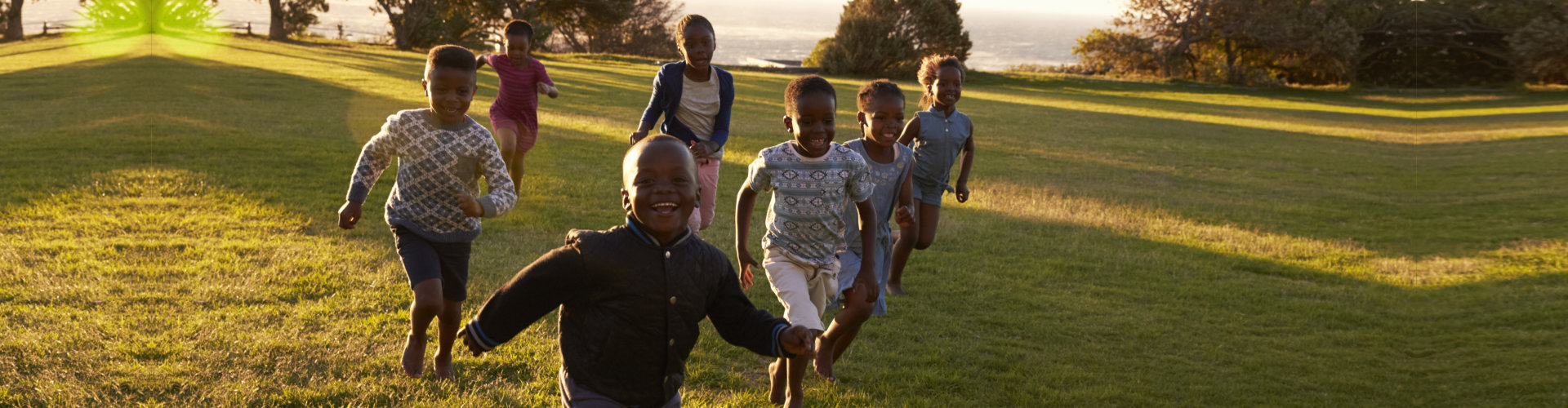African elementary school kids running to camera in a field